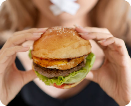 Person holding fast food representing emotional eating